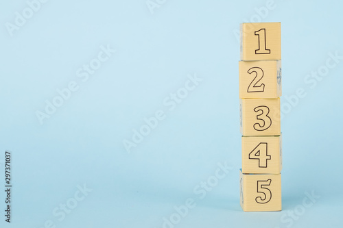 Wooden childrens cubes on a blue background, early childhood development and education