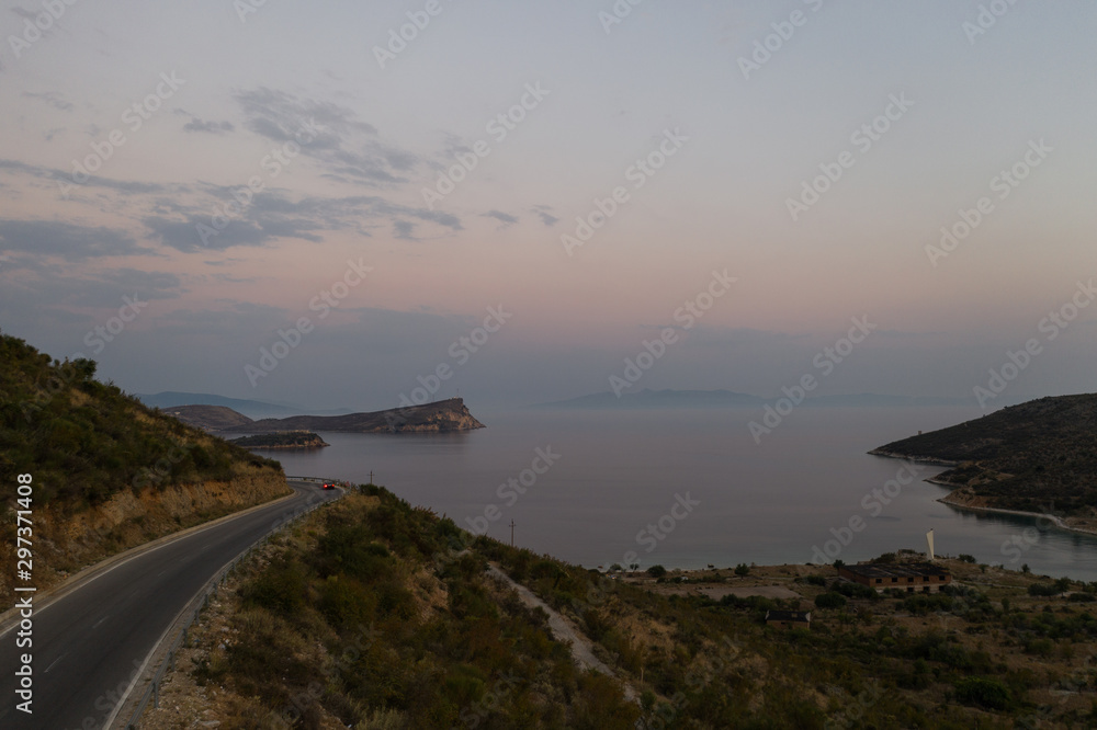 Sea landscape and rural coastal road along the sea, cloudy spring day. Long road near the sea and mountains. Aerial view from flying drone. Wallpaper for postcard Horizontal photo. Sea landscape and rural coastal road along the sea, cloudy spring day. Long road near the sea and mountains. Aerial view from flying drone. Wallpaper for postcard Horizontal photo.
