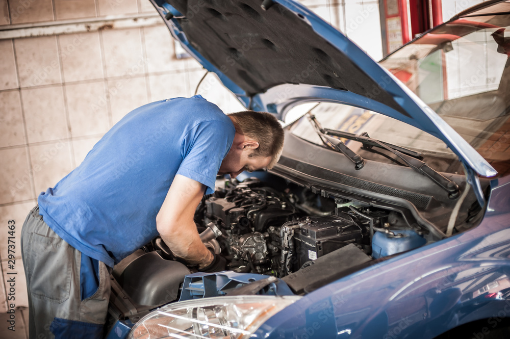 Car mechanic repairer service technician checks and repairs auto engine Car mechanic repairer service technician checks and repairs auto engine