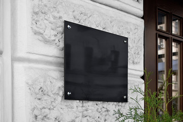 Blank black glass signplate on textured wall mockup