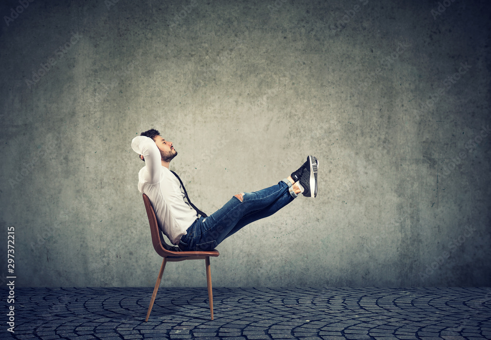 Fototapeta premium Happy casual business man sitting on chair with feet up relaxing