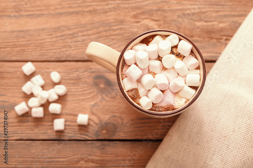 A Cup of traditional Christmas hot chocolate or cocoa with marshmallows on a wooden table, close-up, top view