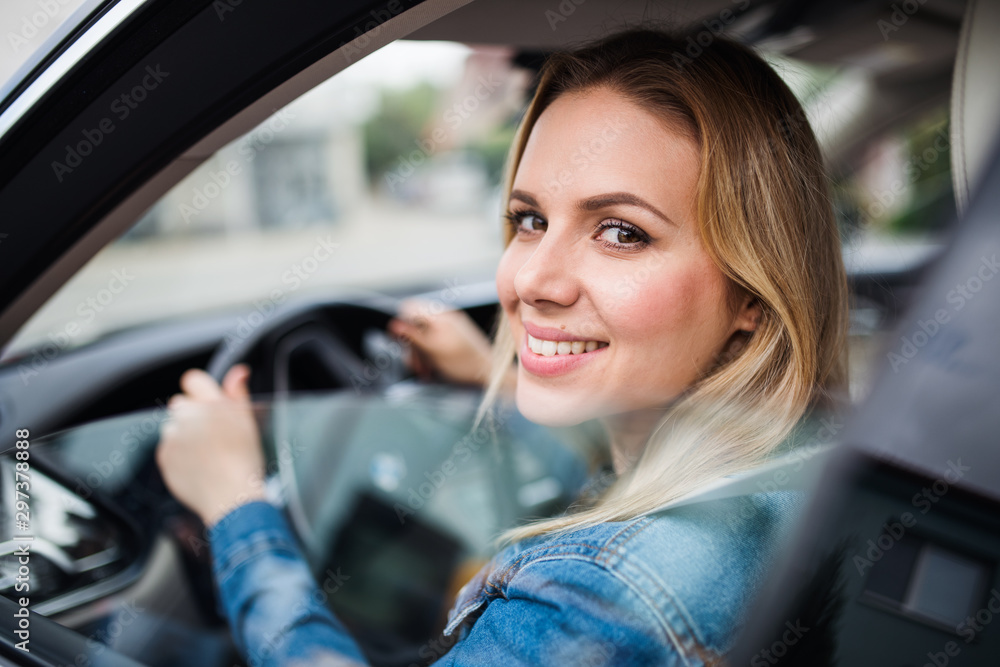 Young woman driver sitting in car, looking out. Young woman driver sitting in car, looking out.