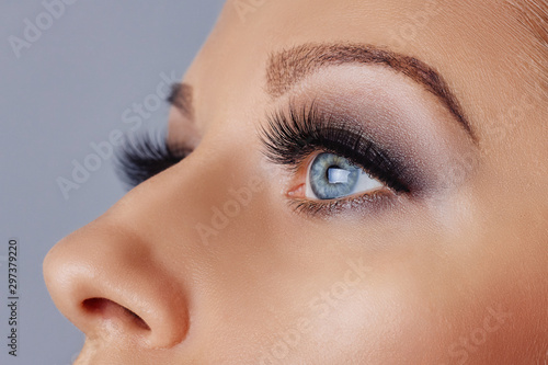 Fototapeta Naklejka Na Ścianę i Meble -  Woman eye with long eyelashes and smokey eyes make-up. Eyelash extensions, makeup, cosmetics, beauty