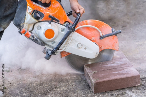 A strong man cuts concrete. Cutting paving stones. Sidewalk construction.