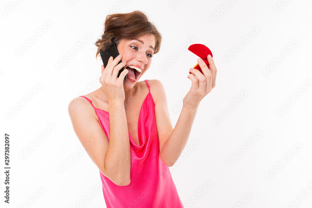 excited bride with a wedding ring in her hands talking on the phone, photo of a girl on a white isolated background excited bride with a wedding ring in her hands talking on the phone, photo of a girl on a white isolated background