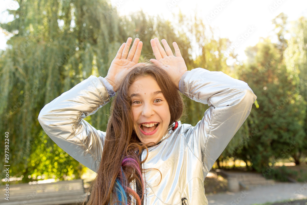 Happy teenager girl smiles and shows her hands over her head. Happy teenager girl smiles and shows her hands over her head.