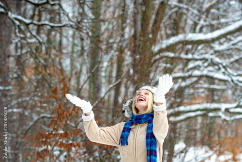 First snow. The girl enjoys the snow in the forest. Winter has come. Cold season. Happy winter woman.
