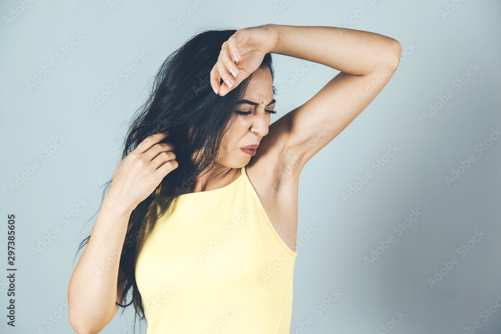 Fototapeta premium woman underarm odor on gray wall background
