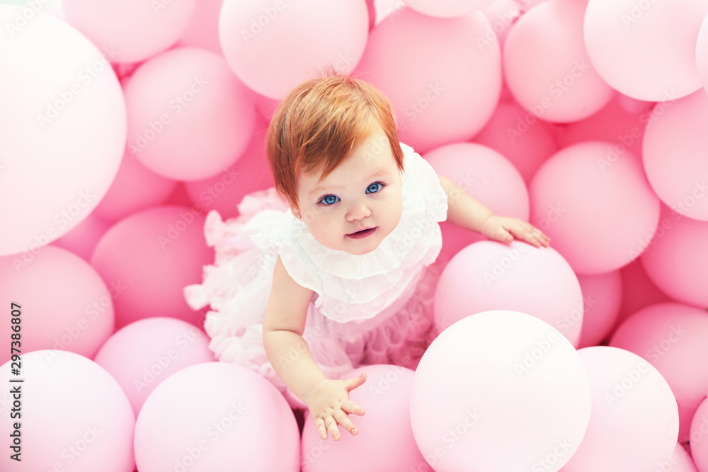 Fototapeta premium beautiful, 11 month baby girl standing among pastel pink balloons