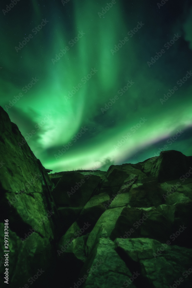 Northern Lights, Aurora Borealis in Kola Peninsula at night sky illuminated green. Murmansk region, Russia