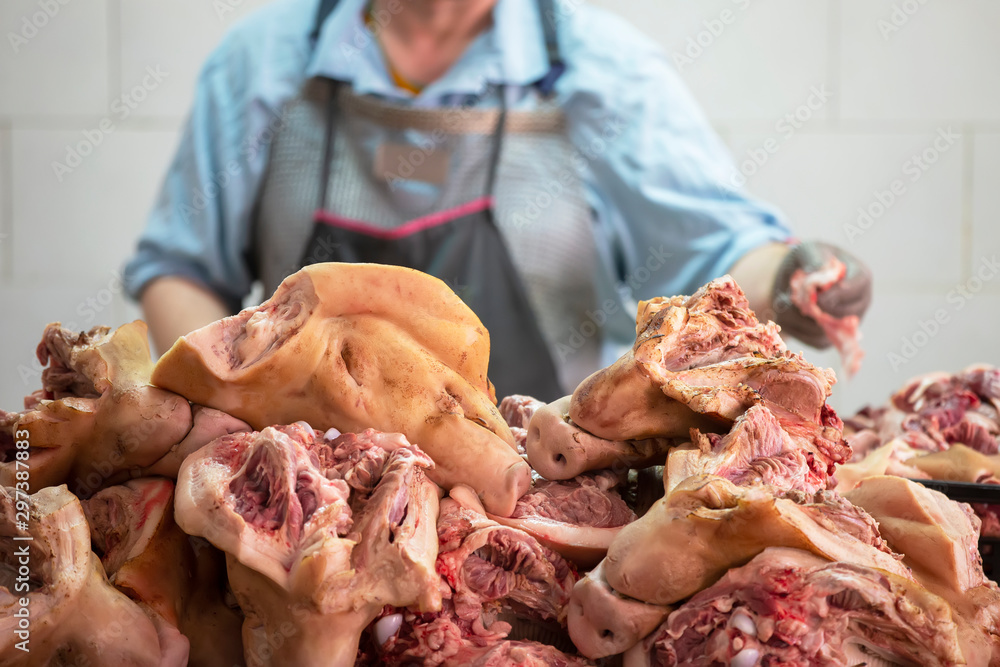 Slaughterhouse. Sliced pork heads on a butcher's background. Pork meat processing
