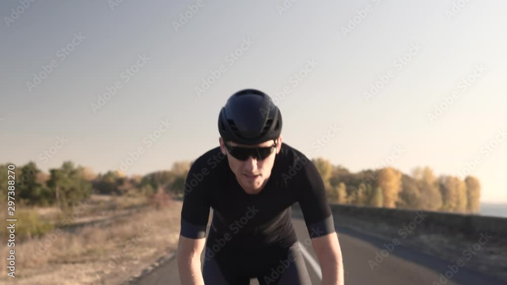 Cycling Triathlete Cyclist For Ironman Race.Athlete Professional Fit Man On Triathlon Bicycle.Cyclist In Helmet Riding On Sunset On Triathlon Time Trial Bicycle.Cycling On Sunset Time Or Dusk. Cycling Triathlete Cyclist For Ironman Race.Athlete Professional Fit Man On Triathlon Bicycle.Cyclist In Helmet Riding On Sunset On Triathlon Time Trial Bicycle.Cycling On Sunset Time Or Dusk.