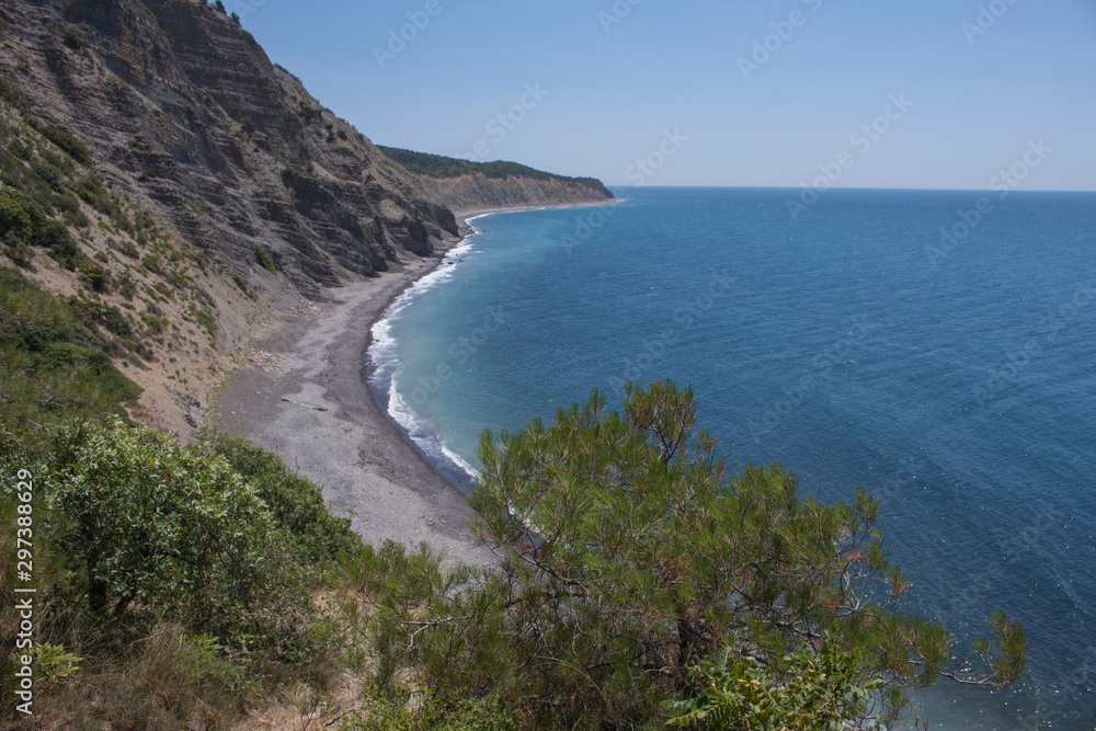 Summer landscape with mountains, azure water, sandy beach and blue sky in bright sunny day. Travel background. Summer landscape with mountains, azure water, sandy beach and blue sky in bright sunny day. Travel background.