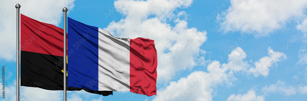Angola and Reunion flag waving in the wind against white cloudy blue sky together. Diplomacy concept, international relations. Angola and Reunion flag waving in the wind against white cloudy blue sky together. Diplomacy concept, international relations.