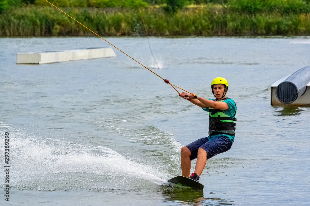Teenager wakeboarding on a lake - Brwinow, Masovia, Poland Teenager wakeboarding on a lake - Brwinow, Masovia, Poland