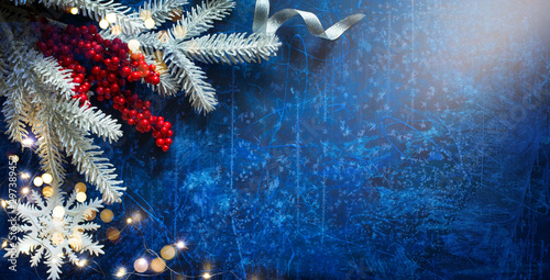 Snow Christmas Tree With Decoration Holiday Lights on Blue Background photo