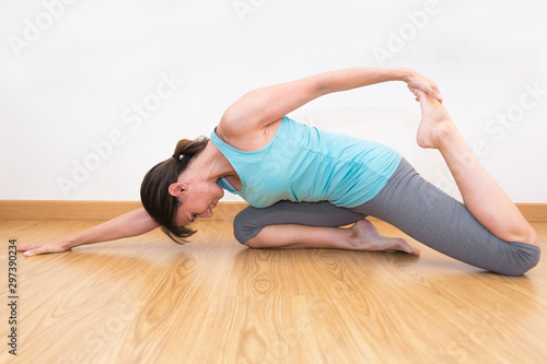 Woman makes yoga position in yoga studio. Yoga practice .
