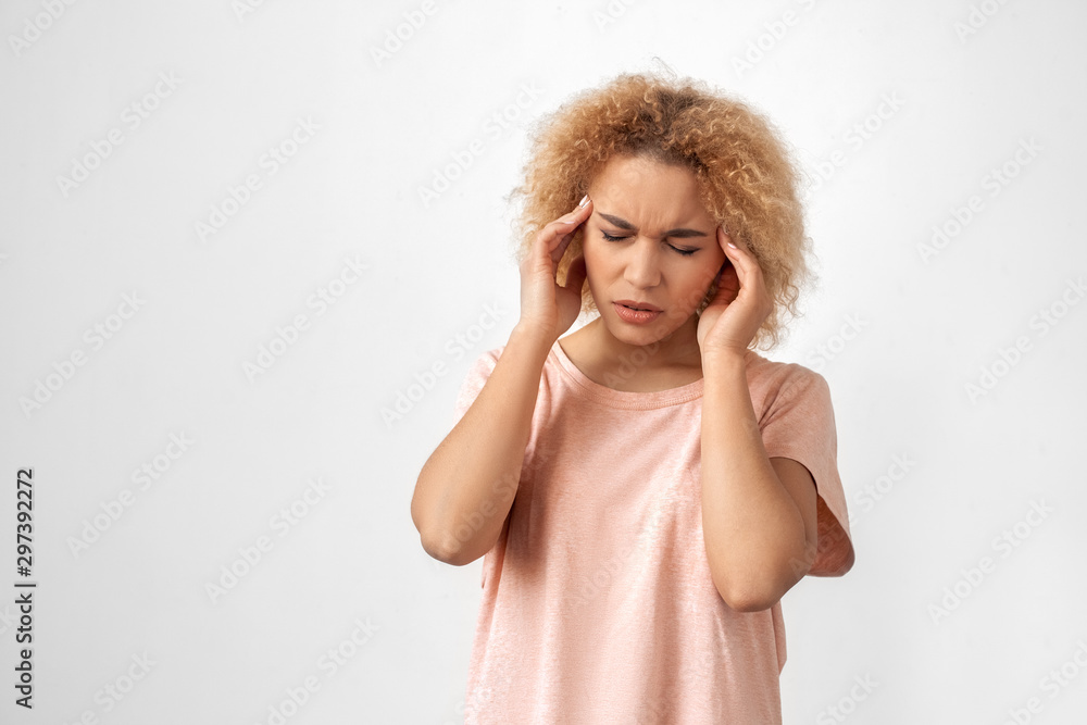 Freestyle. Young woman standing isolated on grey having headache feeling unwell Freestyle. Young woman standing isolated on grey having headache feeling unwell