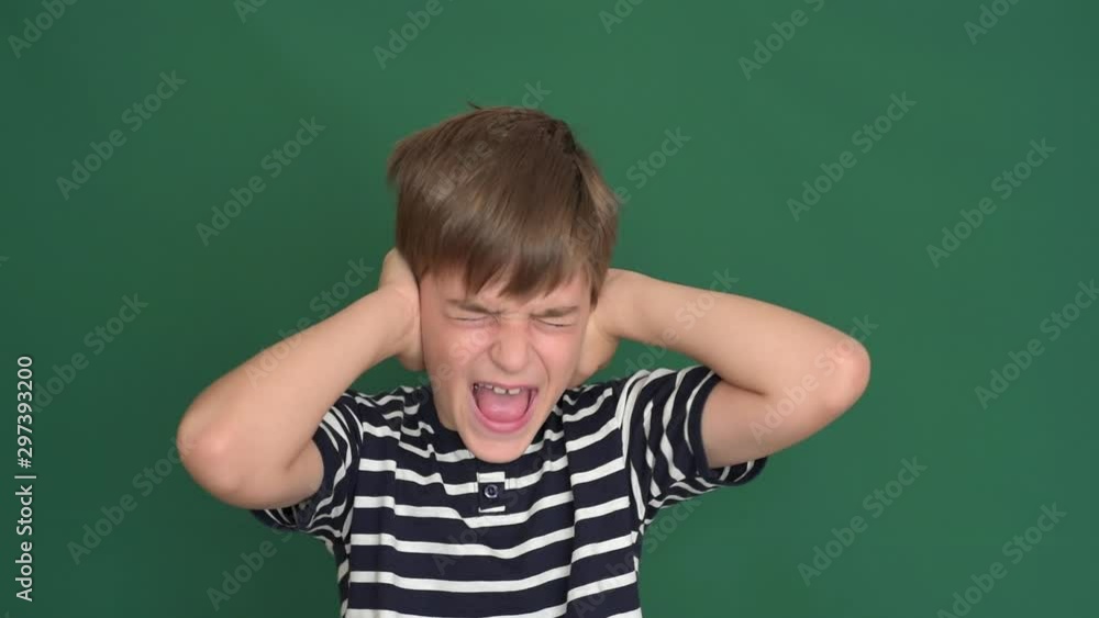 Young boy covering his ears with hands on the green screen Young boy covering his ears with hands on the green screen