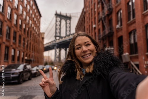 woman taking a selfie near the manhattan bridge in new york