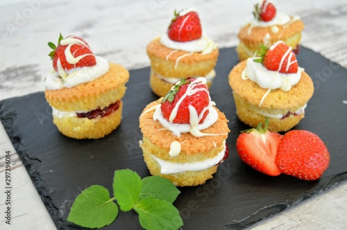 Muffins gefüllt mit Erdbeeren und Sahne auf Schieferplatte
