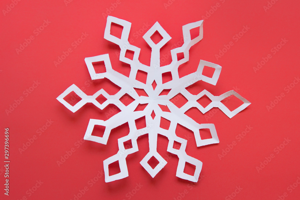 Large white paper snowflake on red backgound Large white paper snowflake on red backgound