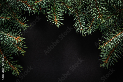 Christmas green frame from fir branches on a black board background. Frame of fir branches. Christmas card blank.