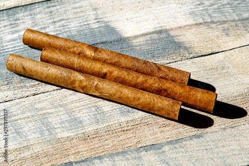 Three cigars on a wooden board