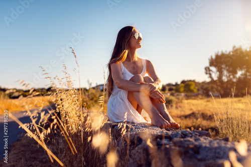 Woman in her vacation sitting on a stone wall in rural Alentejo  Portugal