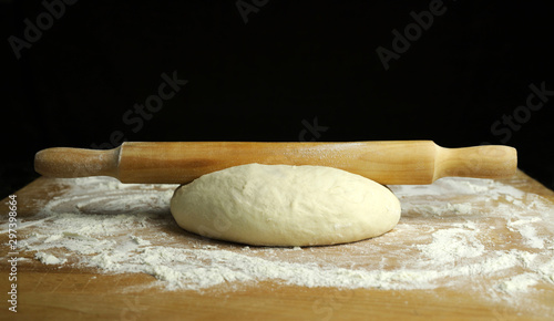 Pasta fresca pronta per la cottura con un mattarello su tavolo di legno infarinato