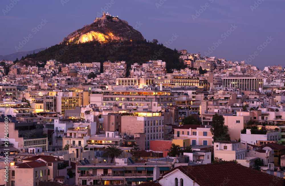 Lycavitos, Lycabettus - a steep, stony conical rocky hill in the center of Athens, the capital of Greece. Evening city landscape