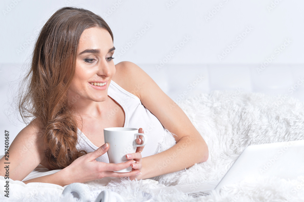 Close up portrait of young brunette woman relaxing in bed