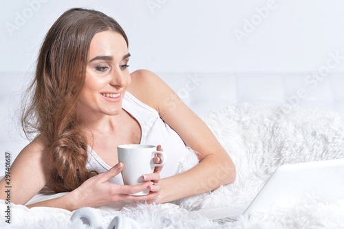 Close up portrait of young brunette woman relaxing in bed