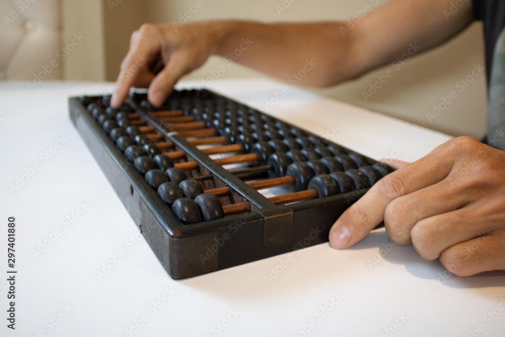 Young male hands holding old abacus performing addition, subtraction, division and multiplication.education mental math.count, add, subtract, multiply.Chinese math and history science. Young male hands holding old abacus performing addition, subtraction, division and multiplication.education mental math.count, add, subtract, multiply.Chinese math and history science.