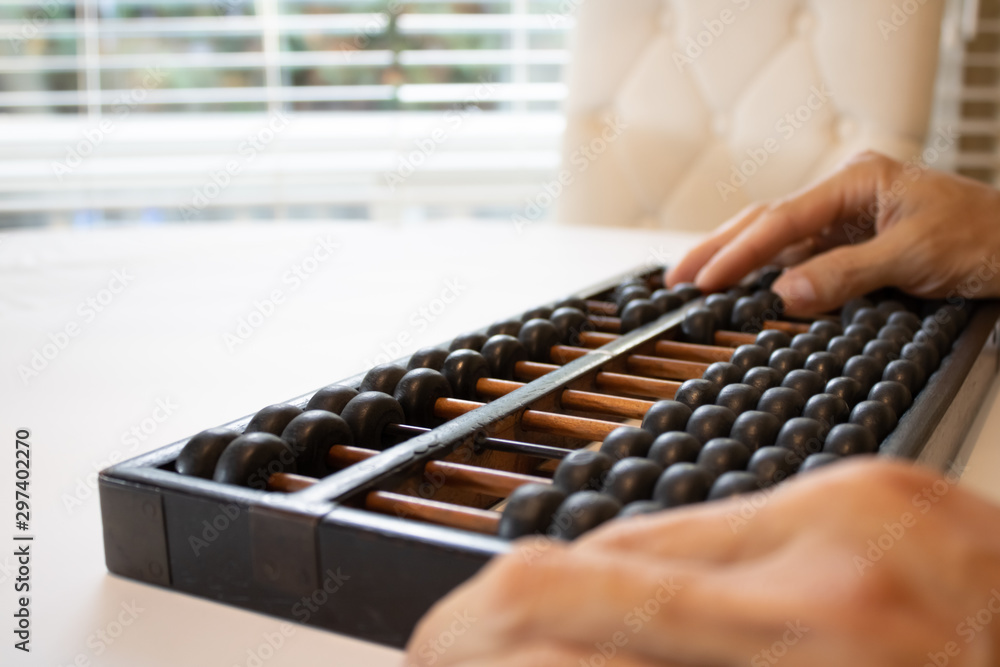 Young male hands holding old abacus performing addition, subtraction, division and multiplication.education mental math.count, add, subtract, multiply.Chinese math and history science. Young male hands holding old abacus performing addition, subtraction, division and multiplication.education mental math.count, add, subtract, multiply.Chinese math and history science.