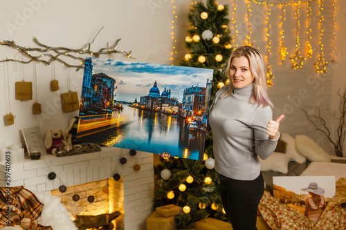 girl holds photo canvas as a christmas present © Angelov