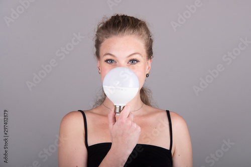 woman with light bulb in front the face