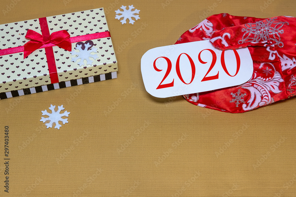 Obraz premium New year 2020 festive background with gift box and snowflake mitten Santa Claus