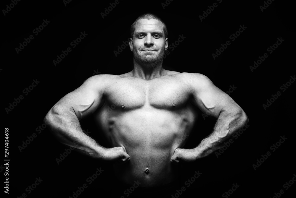 Fototapeta premium sports man standing on a black background, doing sports.