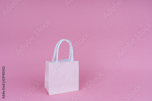 Paper shopping or gift bags on pink background with copy spaсe. Concept sales, shopping, black friday. Giving gift for birthday, christmas and New Year. 