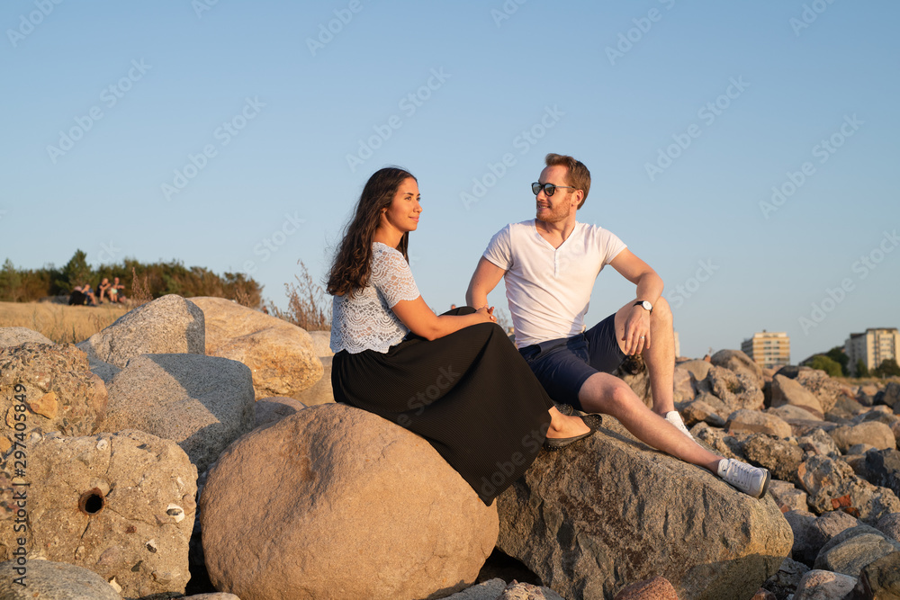 happy couple on rocky coast at sunset