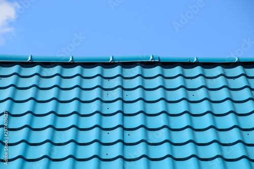 Turquoise metal tiles on roof of the house. Modern roofing materials