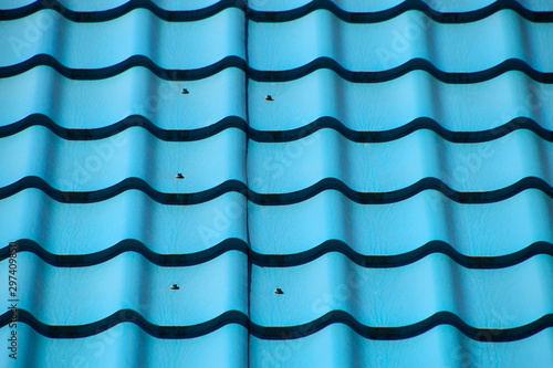 Turquoise metal tiles on roof of the house. Modern roofing materials