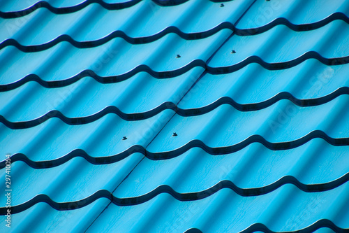 Turquoise metal tiles on roof of the house. Modern roofing materials