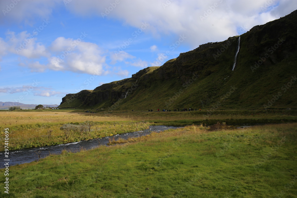 Paisaje en Islandia con agua y campo verde y cielo azul