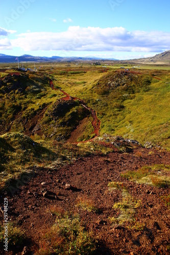 Paisaje en Islandia con agua y campo verde y cielo azul