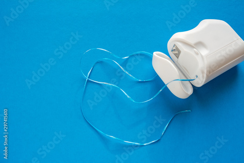 dental floss on a blue background, the concept of care for the oral cavity, preventing tooth decay
