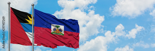Obraz na płótnie Antigua and Barbuda with Haiti flag waving in the wind against white cloudy blue sky together