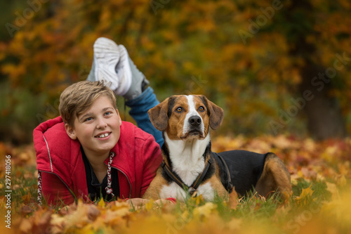 Young boy with his dog in autumn landscape